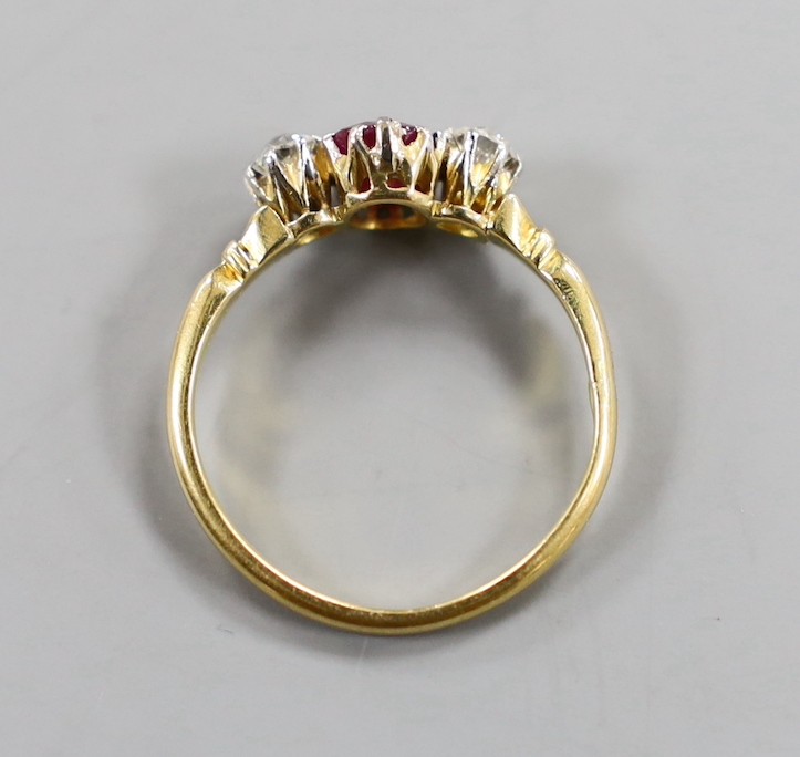 A yellow metal, single stone ruby and two stone diamond set ring, size N, gross weight 2.7 grams.